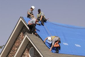 Roofers fixing a storm damaged house