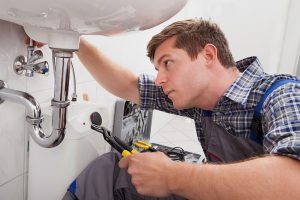 A technician performing plumbing services